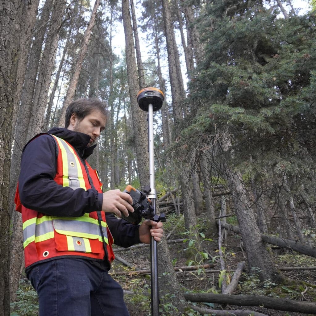 Survey crew working from the back of a pickup truck with GNSS equipment at a construction site