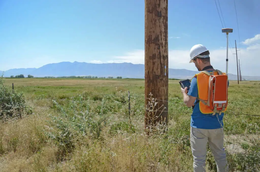 a man surveying with a geode on a backpack.