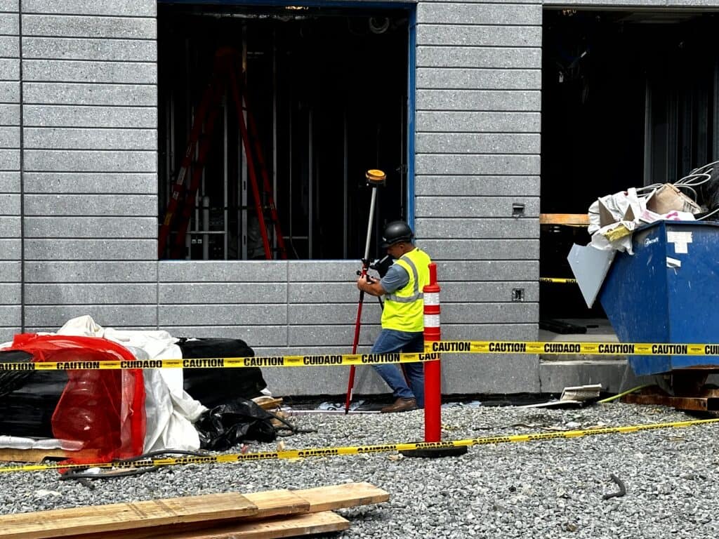 Construction worker surveying at a building site.
