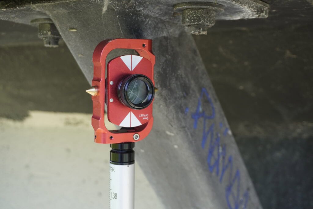 Mini prism mounted on survey pole for total station measurements