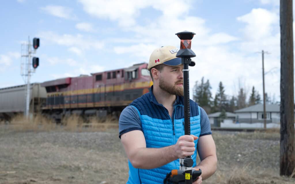 Surveyor using prism pole for total station surveying